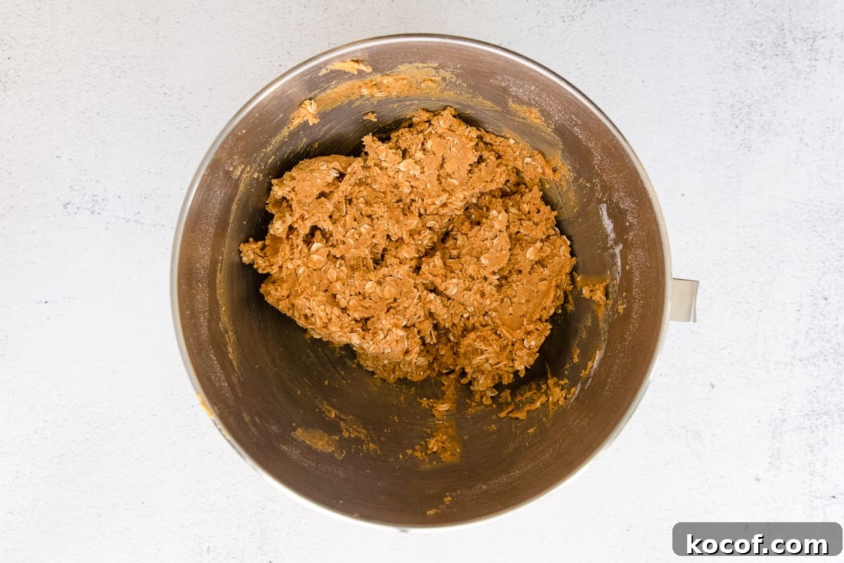 Spooky Halloween Monster Cookie Recipe for Party Treats 12 Peanut butter and oat dough mixture in a mixing bowl.