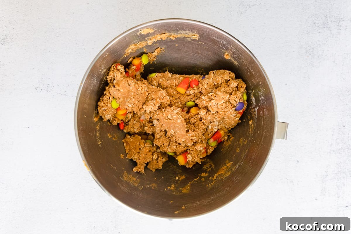 Spooky Halloween Monster Cookie Recipe for Party Treats 13 Cookie dough mixture filled with Halloween candy.