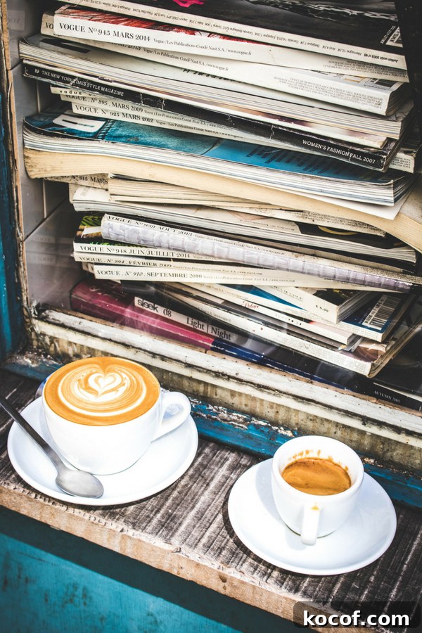 an espresso and a flat white in front of a stack of Vogue magazines