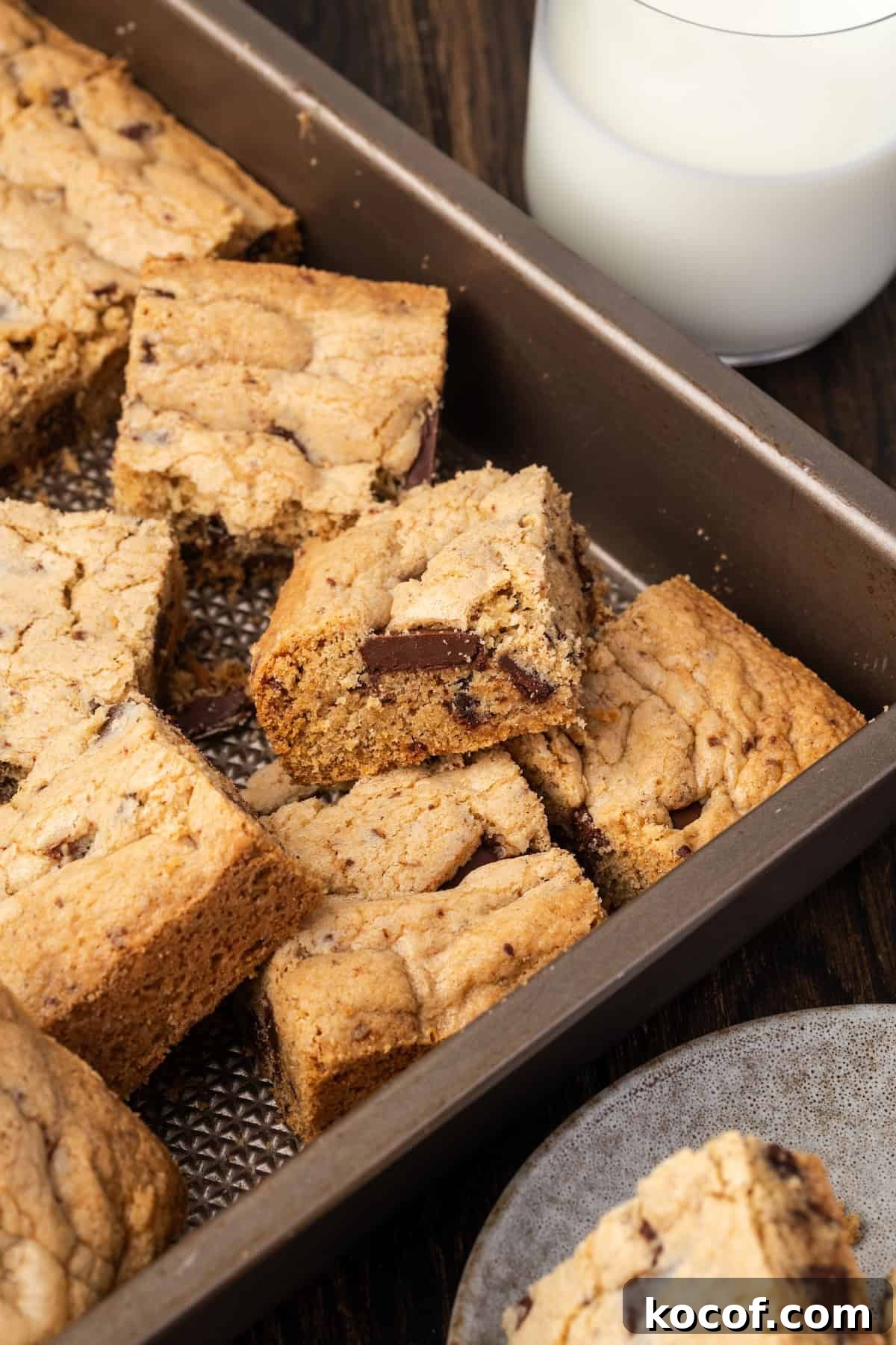 Buttery, chewy chocolate chip cookie bars are easy to make and perfect for baking and slicing into squares, no chilling or rolling required! Assorted chocolate chip cookie bars in a metal pan.
