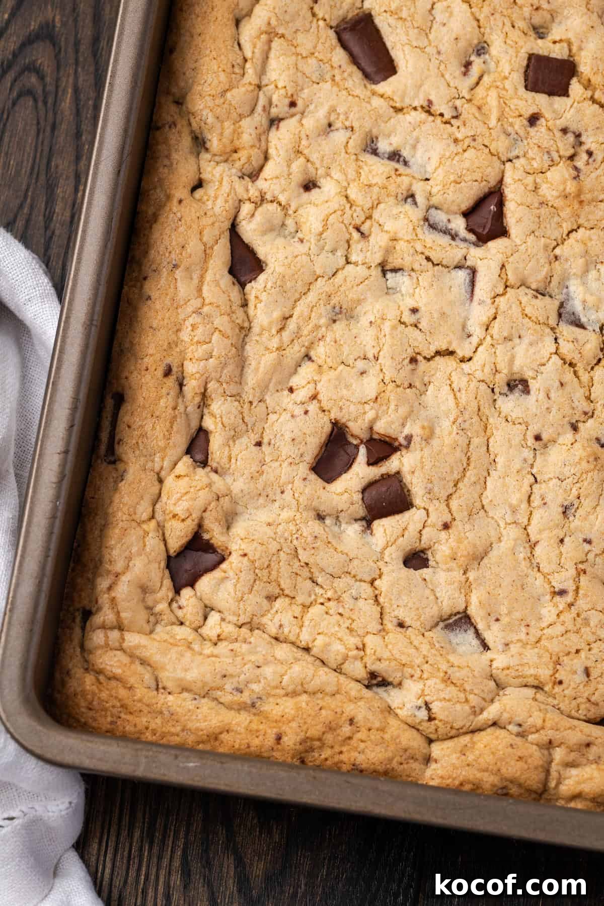 Buttery, chewy chocolate chip cookie bars are easy to make and perfect for baking and slicing into squares, no chilling or rolling required! Overhead view of chocolate chip cookie bars inside a baking pan.