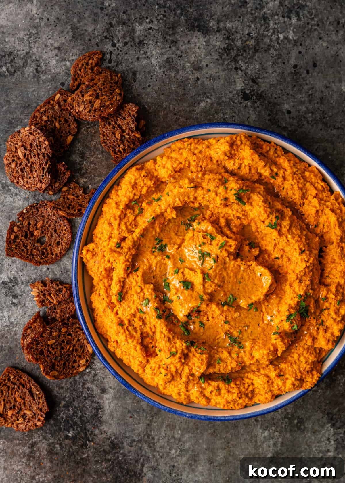 Roasted Carrot and Goat Cheese Dip Recipe for Entertaining 8 overhead: bowl of goat cheese dip on counter with crackers on side