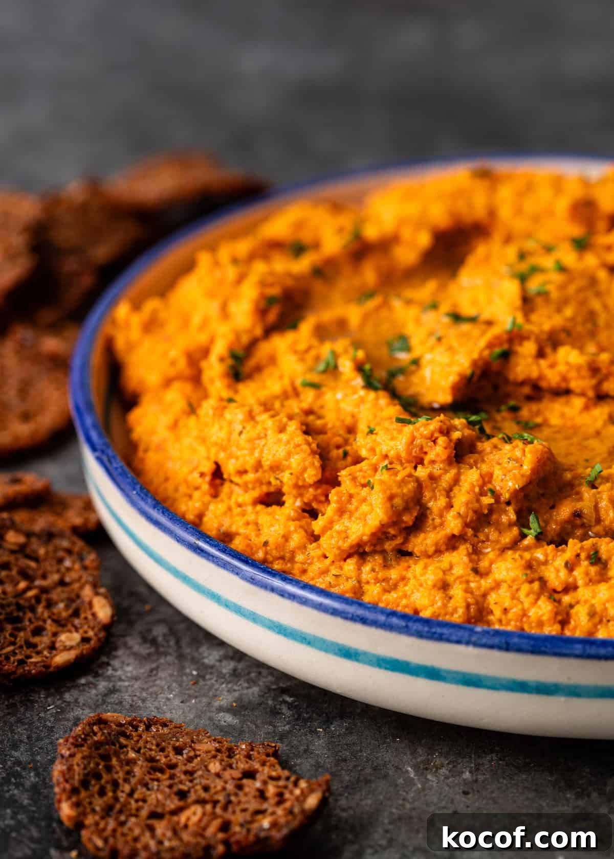 Roasted Carrot and Goat Cheese Dip Recipe for Entertaining 10 closeup side view: bowl of goat cheese dip with crackers on side