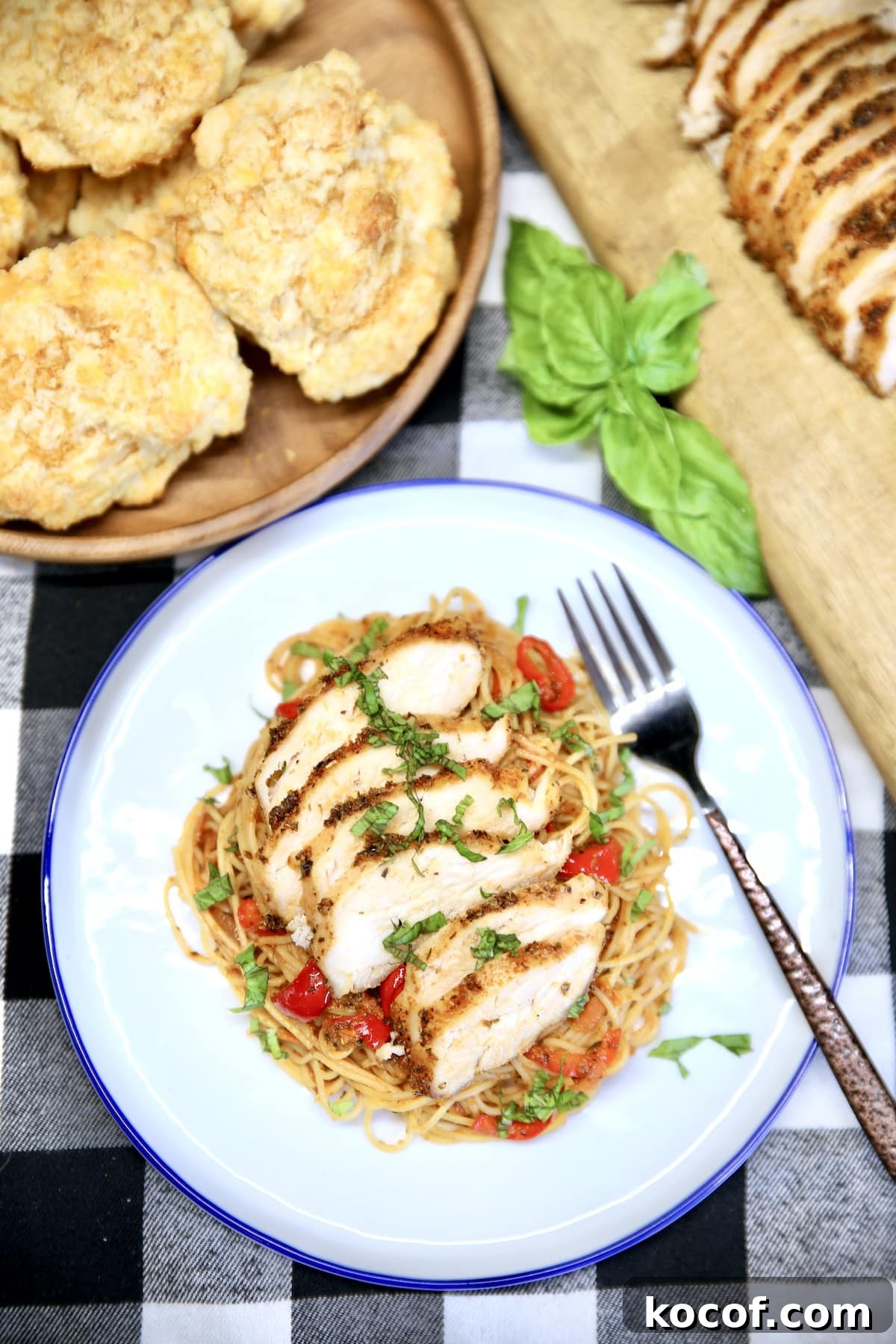 Grilled Chicken Spaghetti Recipe with Smoky Garlic Sauce 2 Plate of grilled chicken spaghetti, bowl of biscuits, sliced chicken on the side.