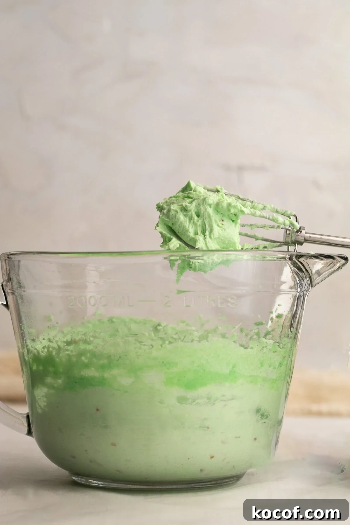 pistachio whipped pudding on beaters over a mixing bowl