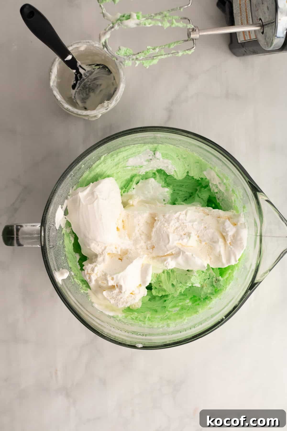 cool whip being added to a mixing bowl with pudding