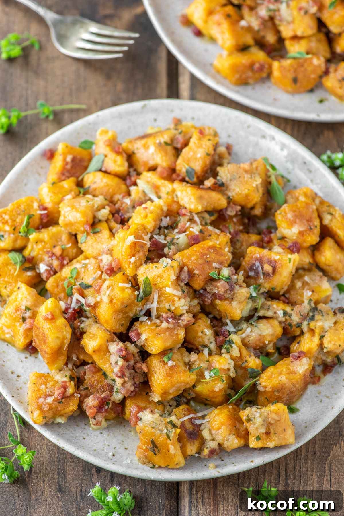 Homemade gnocchi on speckled plate.