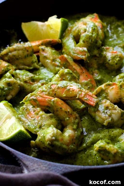 Garlic Butter Shrimp Served in Creamy Avocado Halves 7 Close-up photo of Shrimp in Avocado Butter garnished with lime wedges.