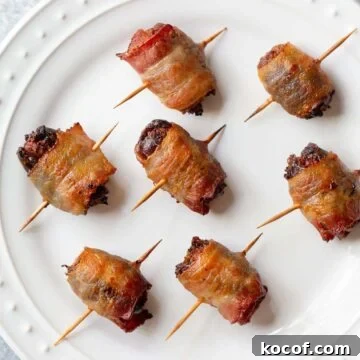 Crispy Air Fryer Stuffed Dates with Goat Cheese & Bacon 8 Cooked bacon wrapped dates on a plate.