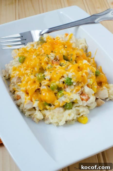 Chicken orzo casserole on a white plate with a fork