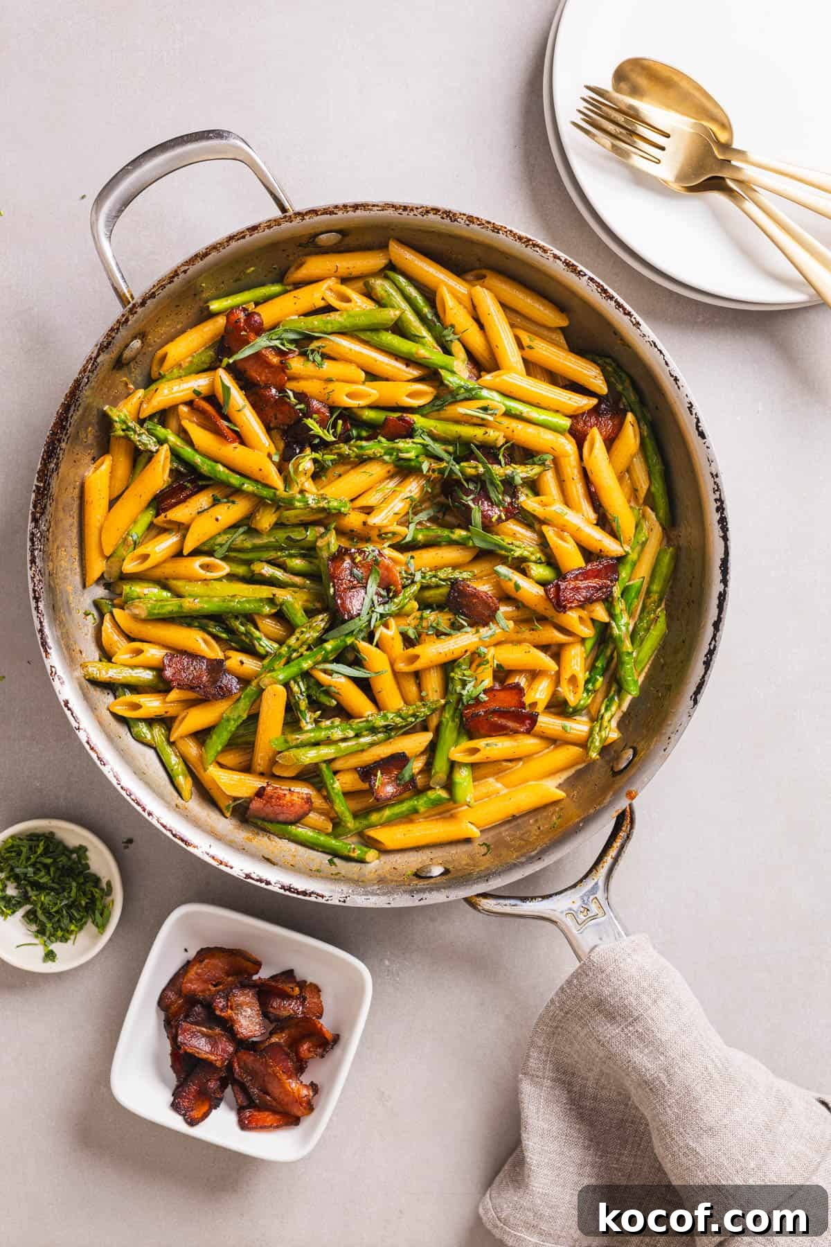Creamy Bacon and Asparagus Pasta Recipe for Spring Meals 2 A skillet with bacon and asparagus pasta in a light cream sauce garnished with chopped tarragon.