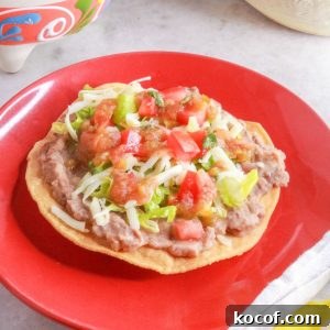 Refried Bean Tostadas with Crispy Tortillas and Fresh Salsa 11 A red plate with a tostada de frijoles (bean tostada)