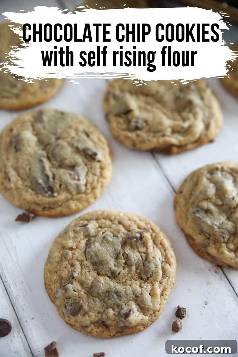 Soft and chewy chocolate chip cookies made with self-rising flour, loaded with melty chocolate lined on a white wood looking background