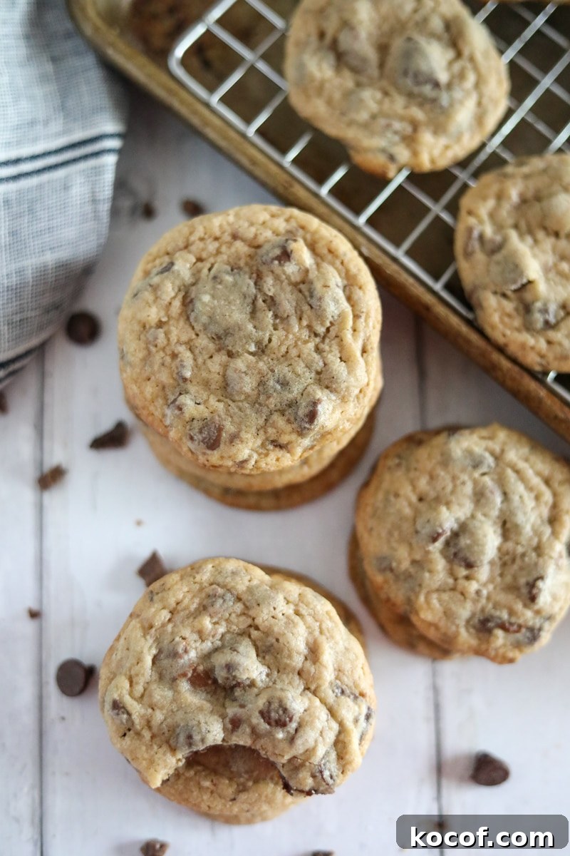 three stacks of chocolate chip cookies with a sheet pan in the background