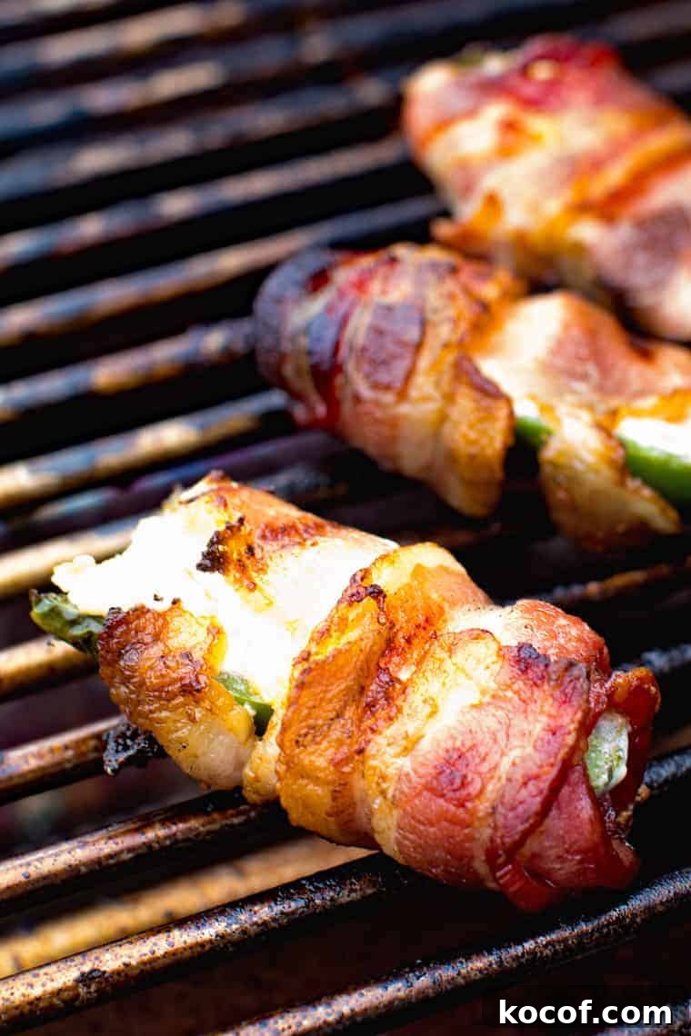 Bacon-Wrapped Jalapeño Poppers: Baked or Grilled Recipes 5 Jalapeno poppers wrapped in bacon on a grill grate