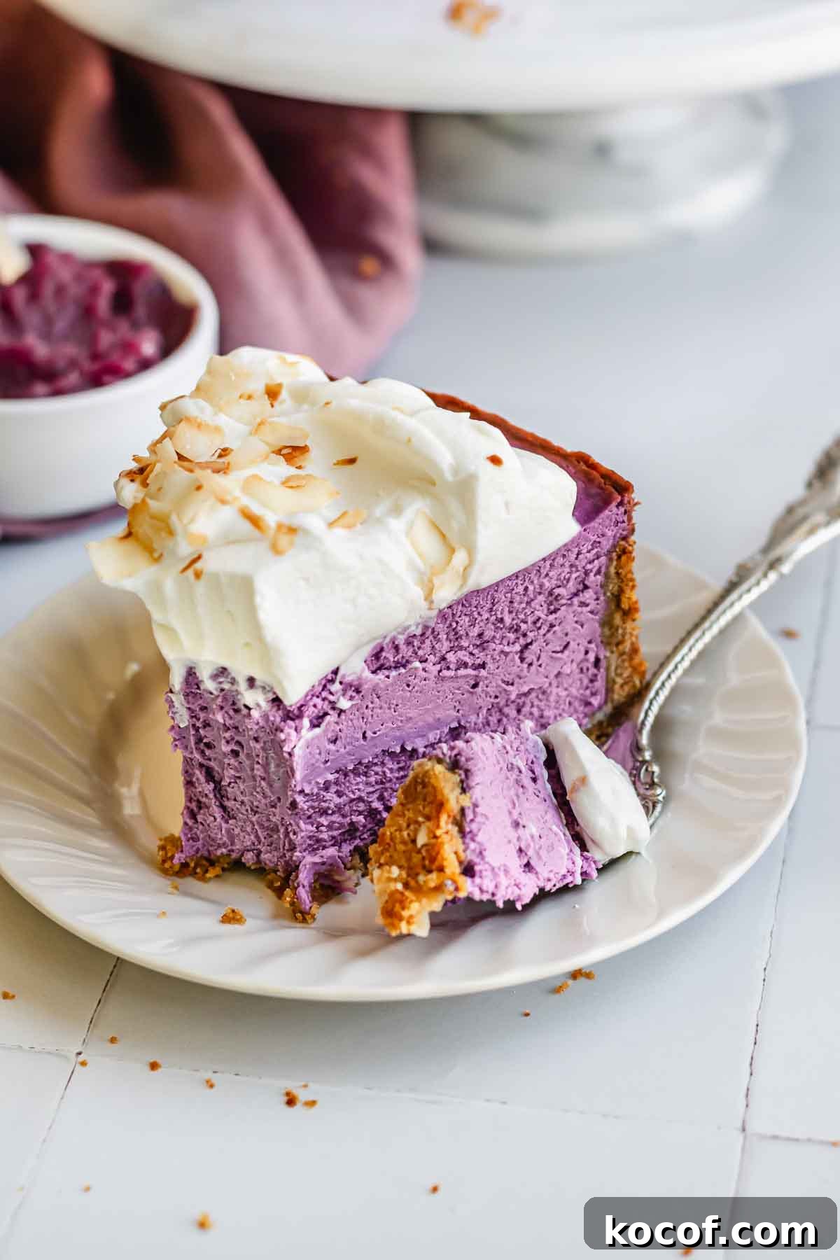 Creamy Ube Cheesecake Recipe: Filipino Purple Yam Dessert 15 A fork with a piece of ube cheesecake on a plate.