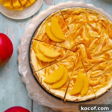 No bake mango cheesecake half sliced with mangoes on the slices.