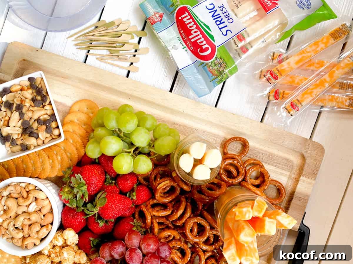kid friendly charcuterie board with pretzels, nuts, cheeses and fruit.