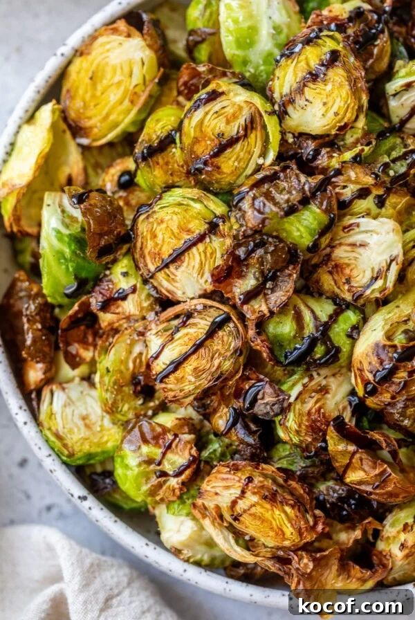 air fryer brussels sprouts in a bowl with balsamic vinegar drizzled overtop