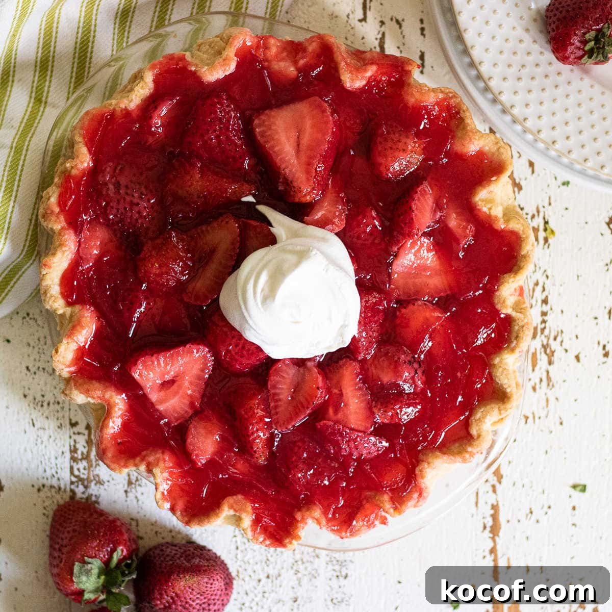Classic Summer Strawberry Dessert Recipes You’ll Love 5 Overhead view of strawberry pie garnished with whipped cream.