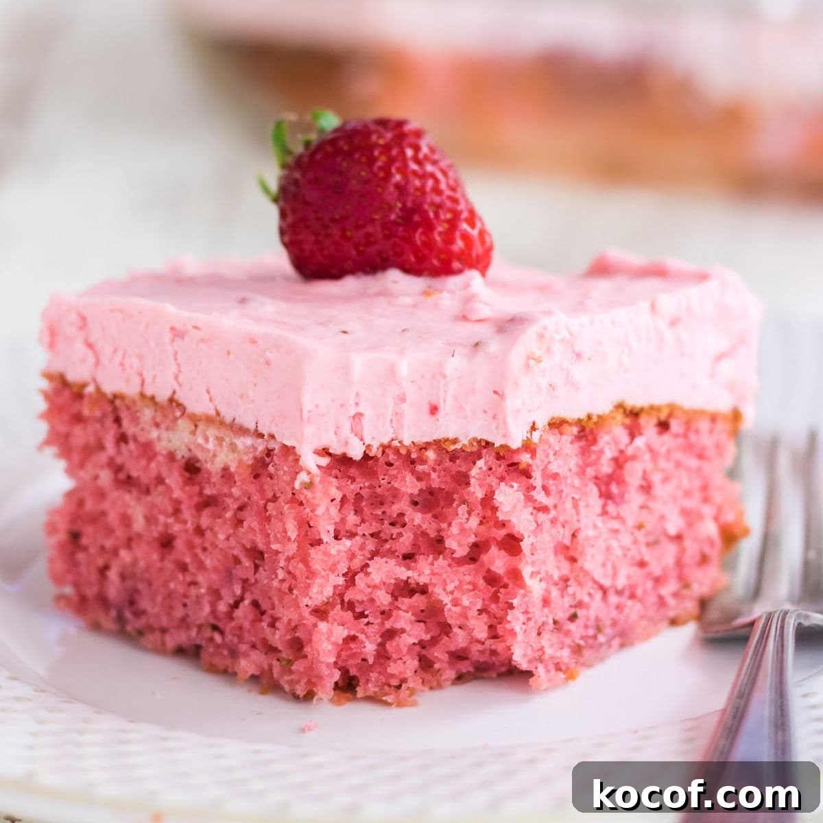 Classic Summer Strawberry Dessert Recipes You’ll Love 9 Closeup of a square of strawberry cake with a berry on top.