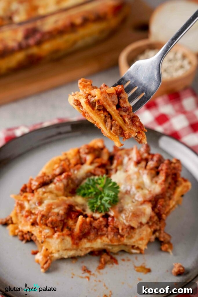 Gluten-Free Lasagna Made Faster: Time-Saving Shortcuts 8 Gluten-Free lasanga on a plate with a fork holding a bite.