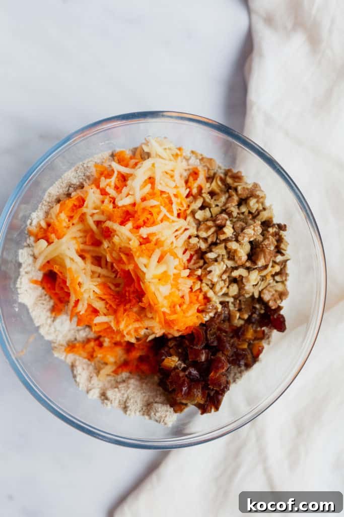 overhead view of shredded carrot, apple, date and walnuts in a bowl