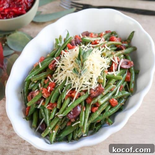 Italian green beans in a white scalloped dish on a beige tablecloth.