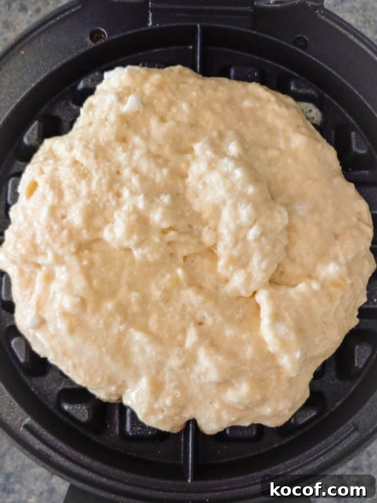 batter on a waffle iron ready to cook.