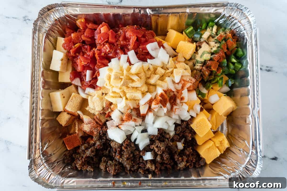 cold queso ingredients in an aluminum pan.