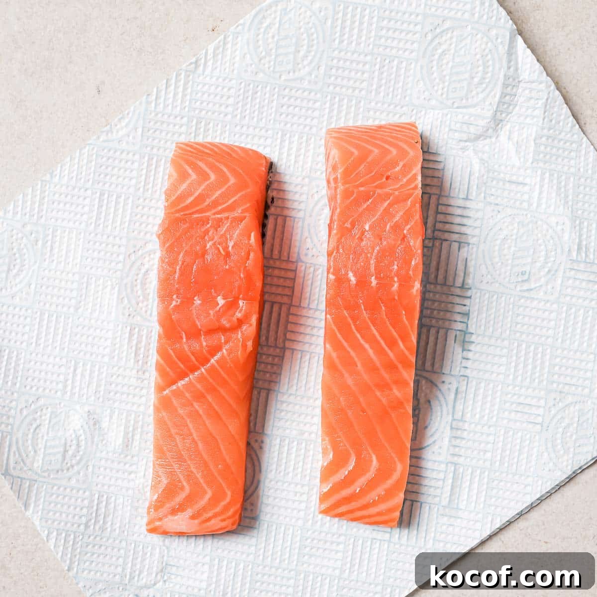 Two pieces of salmon on a piece of paper.