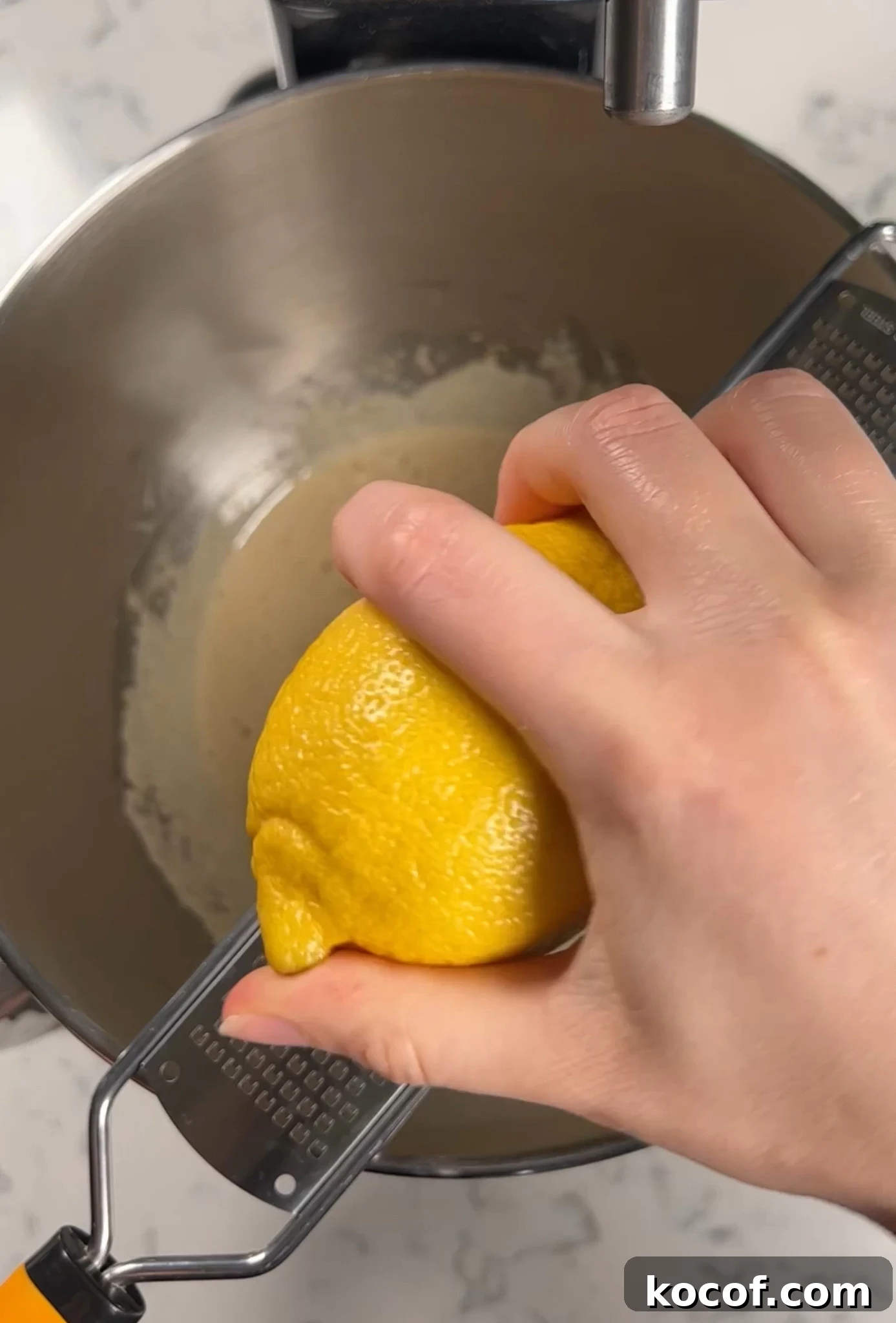 Adding lemon zest to the cake batter.