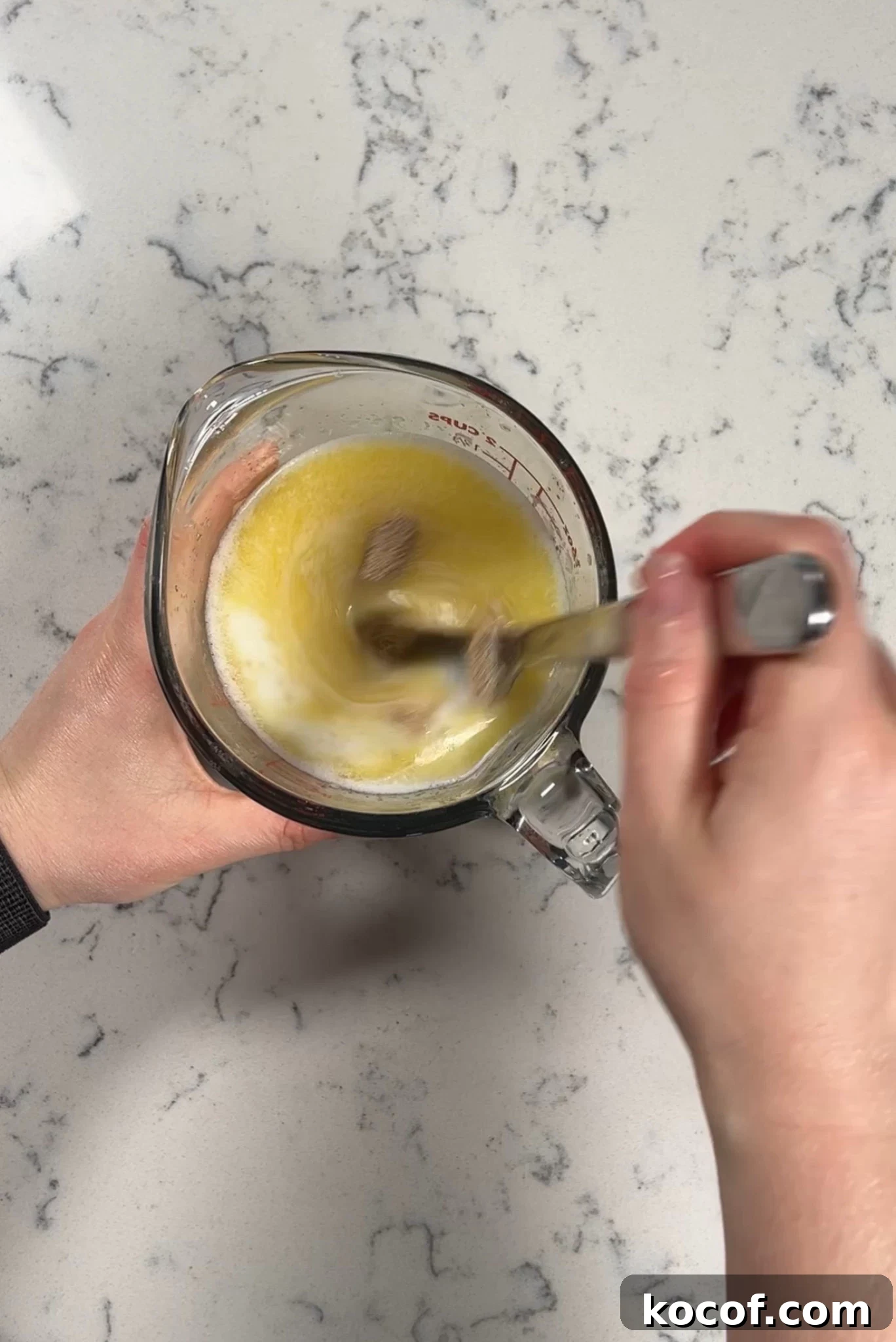 Mixing together yeast, milk, and melted butter.