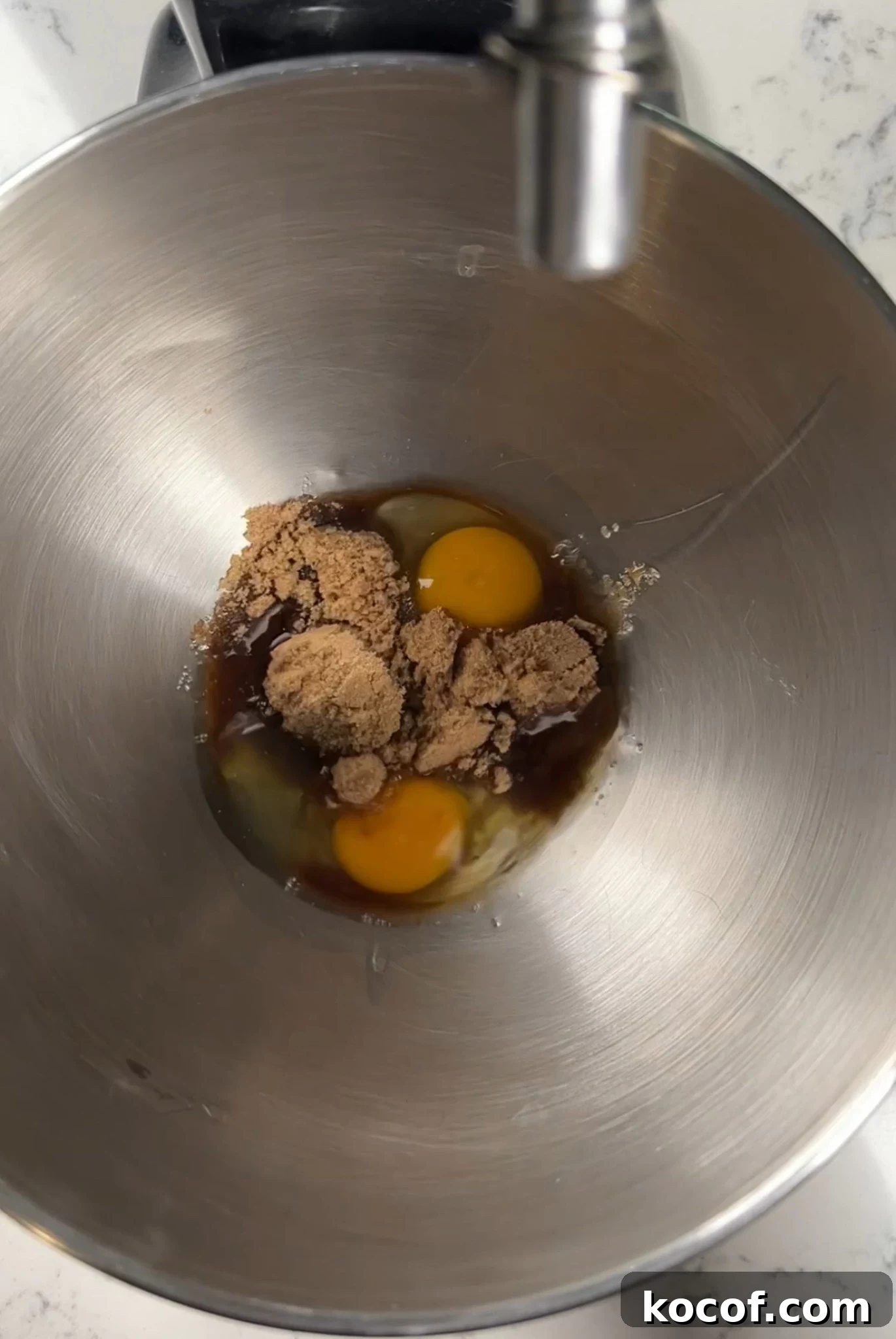 Eggs and sugar in a mixing bowl.