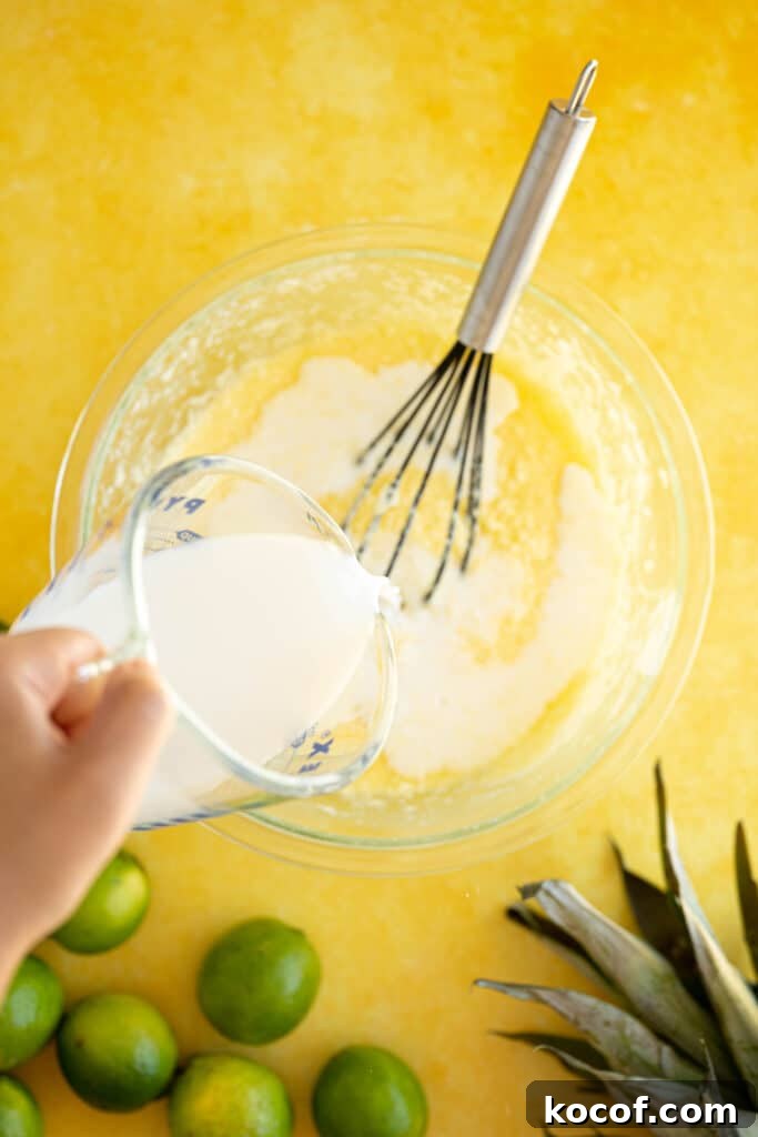 Moist Piña Colada Cake with Fresh Pineapple and Coconut 5 milk pouring into a bowl