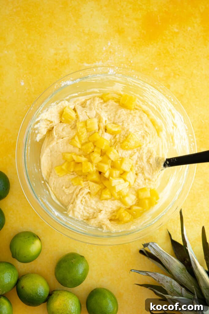 Moist Piña Colada Cake with Fresh Pineapple and Coconut 6 pineapple chunks in a bowl of cake batter
