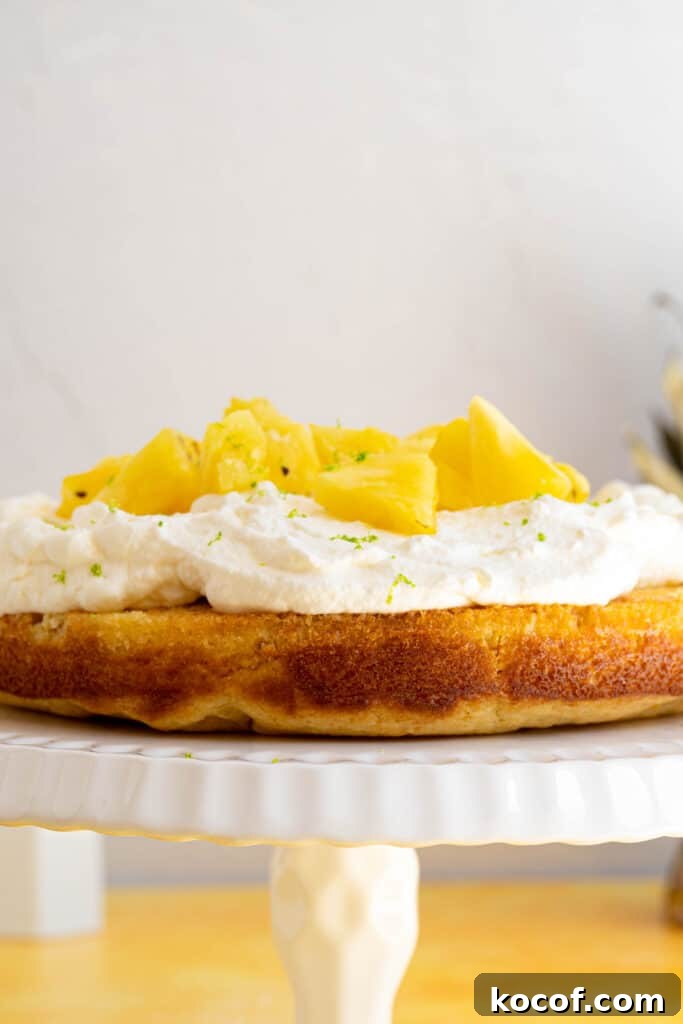 Moist Piña Colada Cake with Fresh Pineapple and Coconut 10 a pina colada cake on a platter