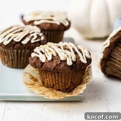 Muffins sitting on a blue cutting board next to a white pumpkin.