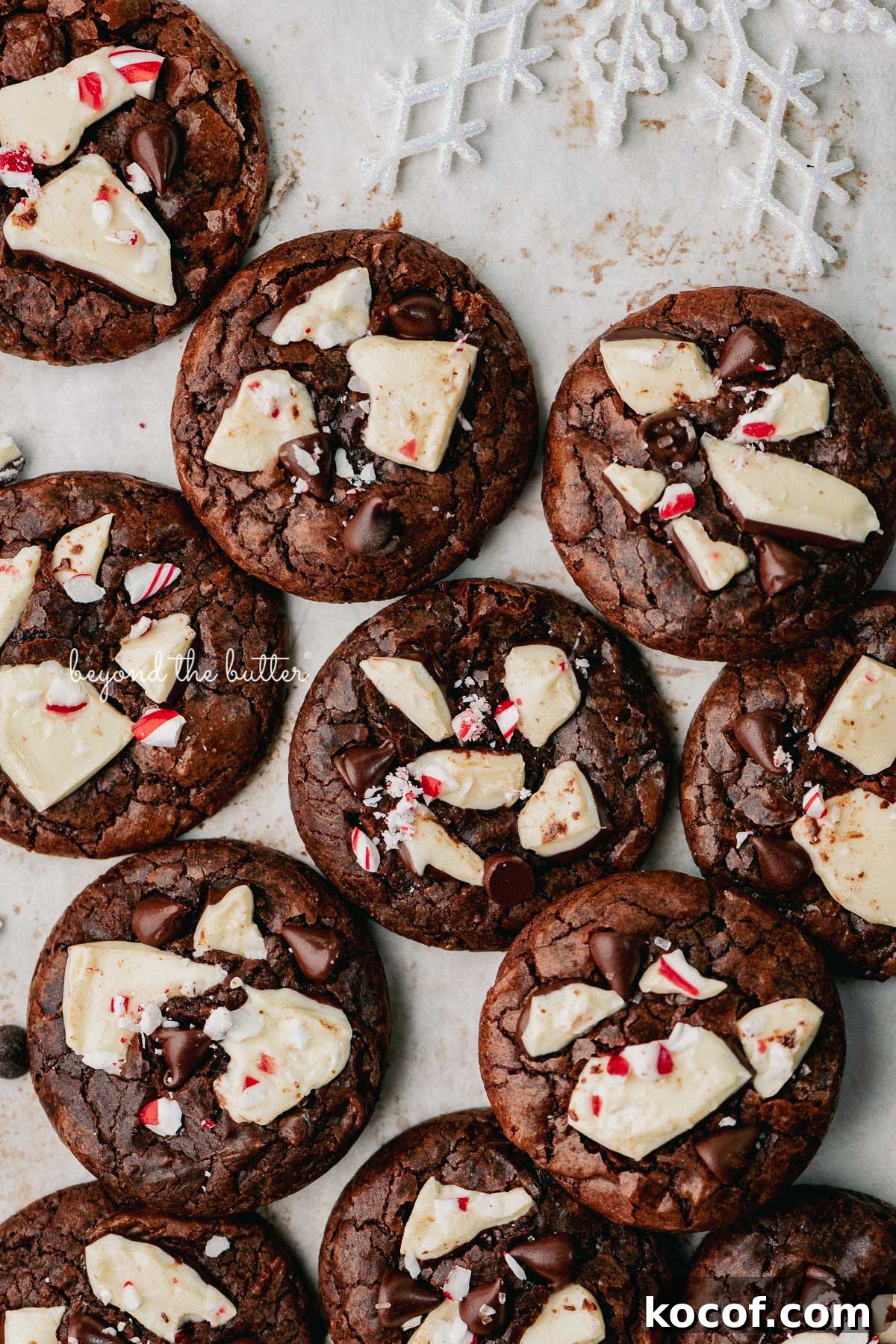 Just baked peppermint bark brownie crinkle cookies on a parchment paper lined baking sheet | © Beyond the Buter®