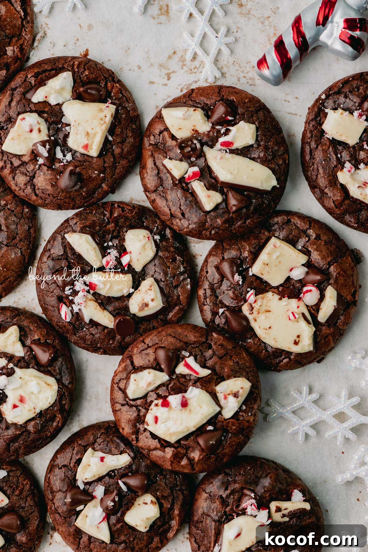 Just baked peppermint bark brownie crinkle cookies on a parchment paper lined baking sheet | © Beyond the Buter®