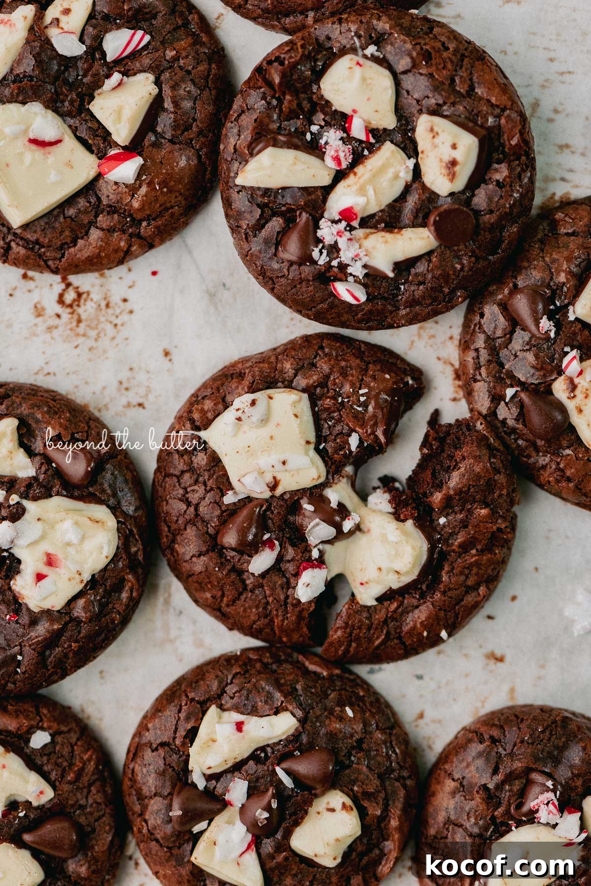 Just baked peppermint bark brownie crinkle cookies on a parchment paper lined baking sheet | © Beyond the Buter®