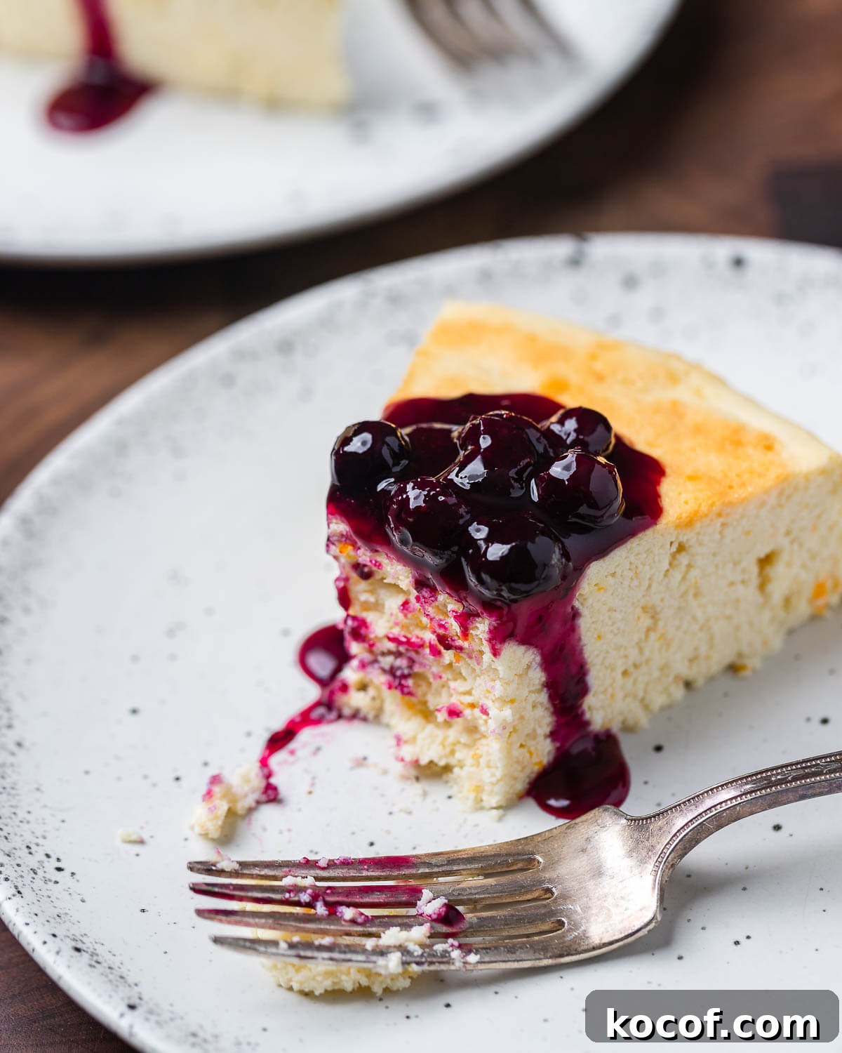 Authentic Italian Cheesecake Recipe: Classic Torta della Nonna Style 8 Italian cheesecake slice with bite taken out of it on white plate.