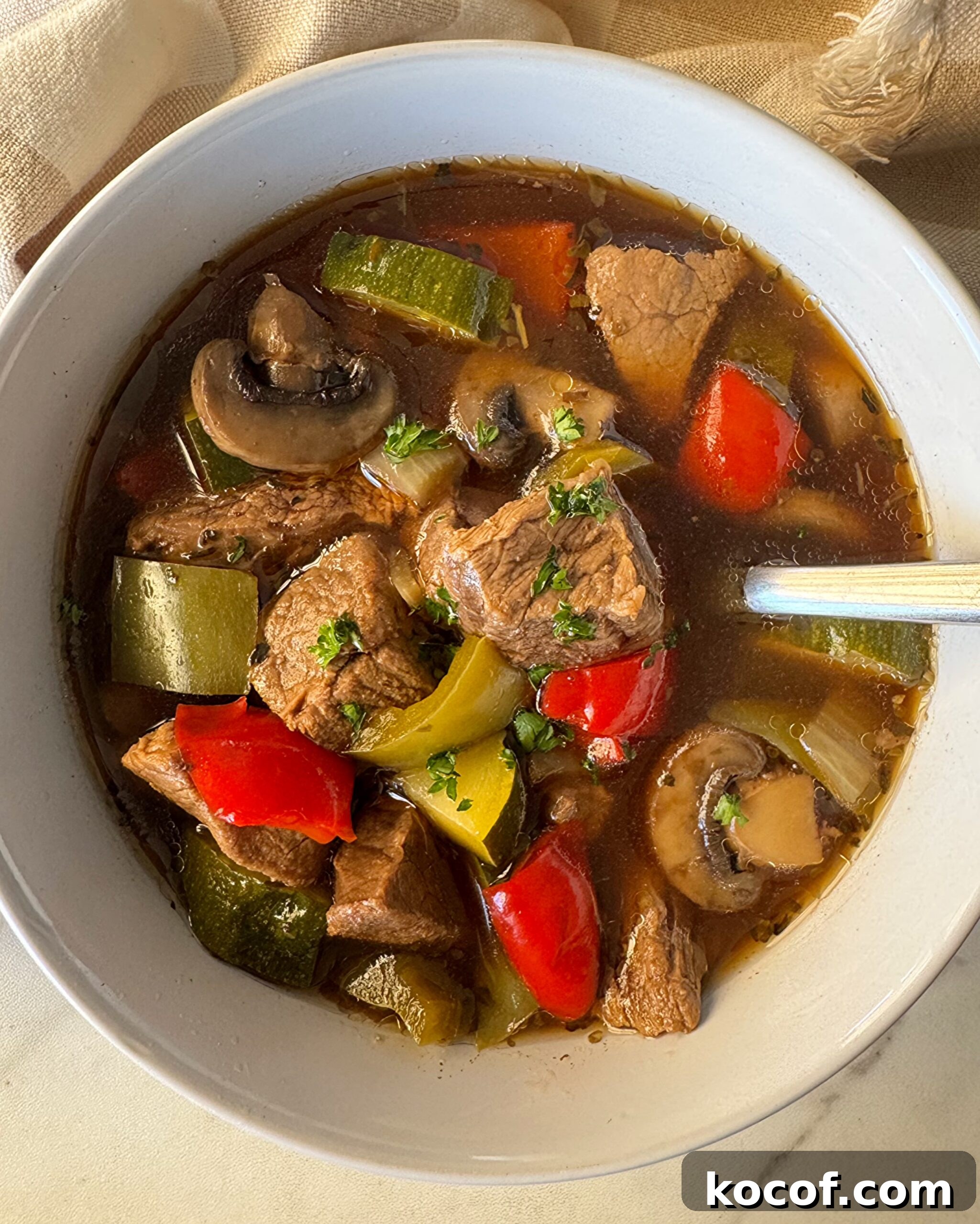 overhead shot of beef kebab soup in a white bowl