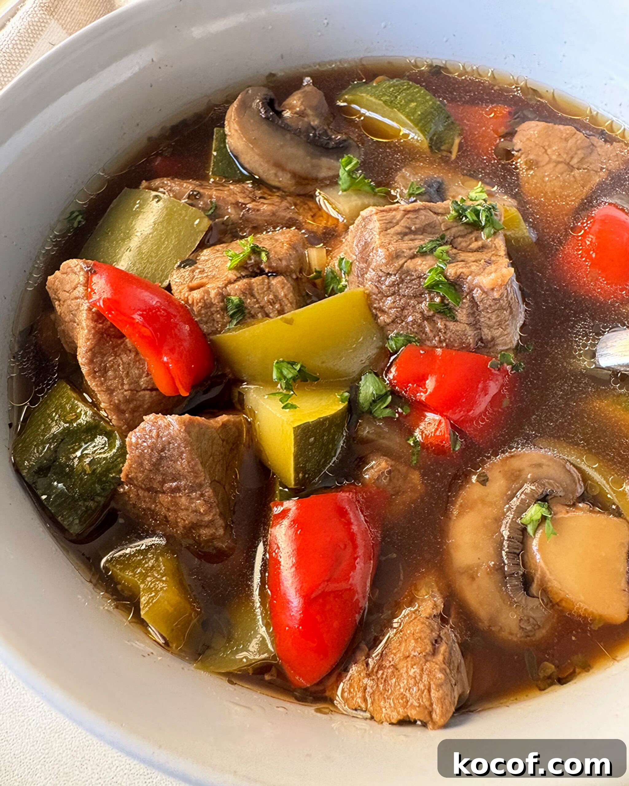 close up shot of beef kebab soup in a white bowl