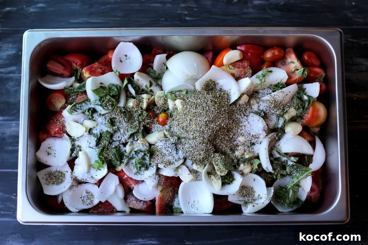 Large aluminum pan filled with herbs, spice and tomatoes.
