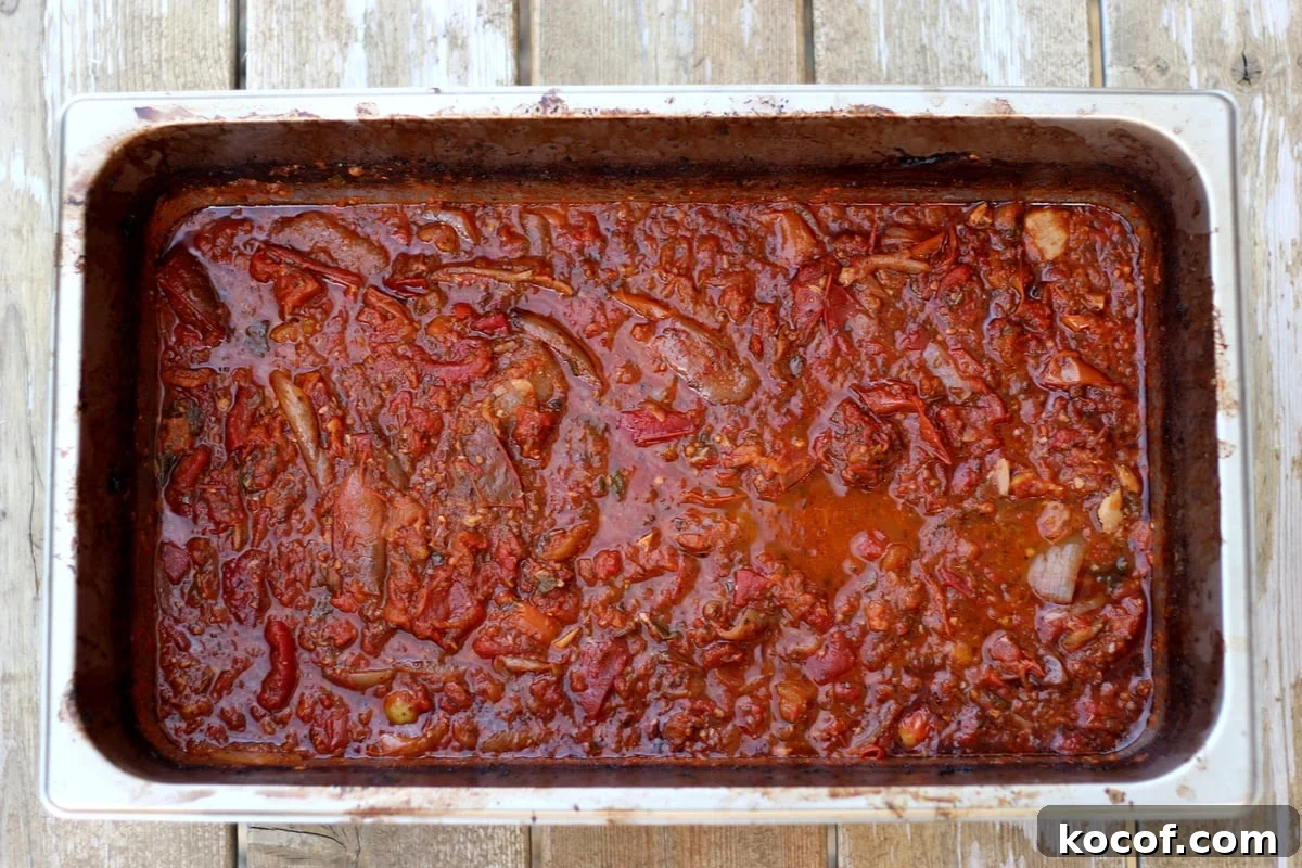 Large aluminum pan with roasted marinara sauce in it.