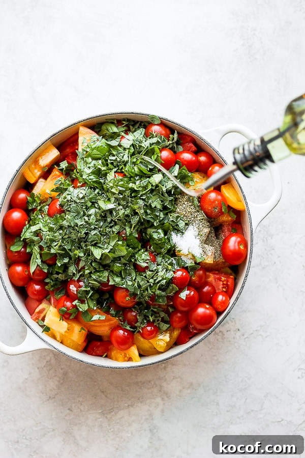 Someone pouring olive oil into dutch oven filled with tomatoes and herbs.