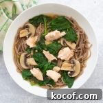 bowl of salmon miso soup with soba noodles, spinach and mushrooms