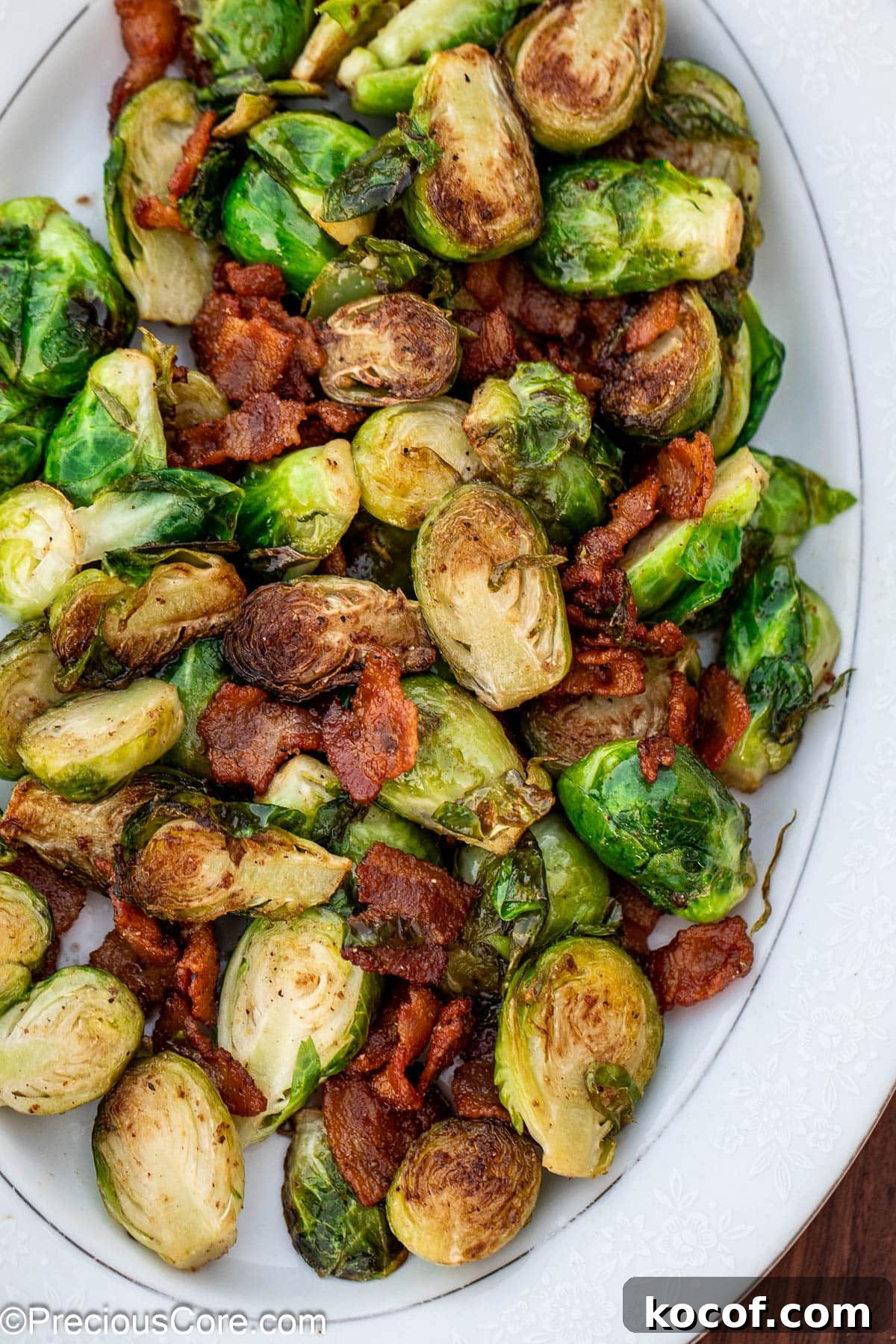 Crispy Pan-Fried Brussels Sprouts with Bacon and Garlic 3 Cooked bacon and Brussels sprouts on a white serving plate.