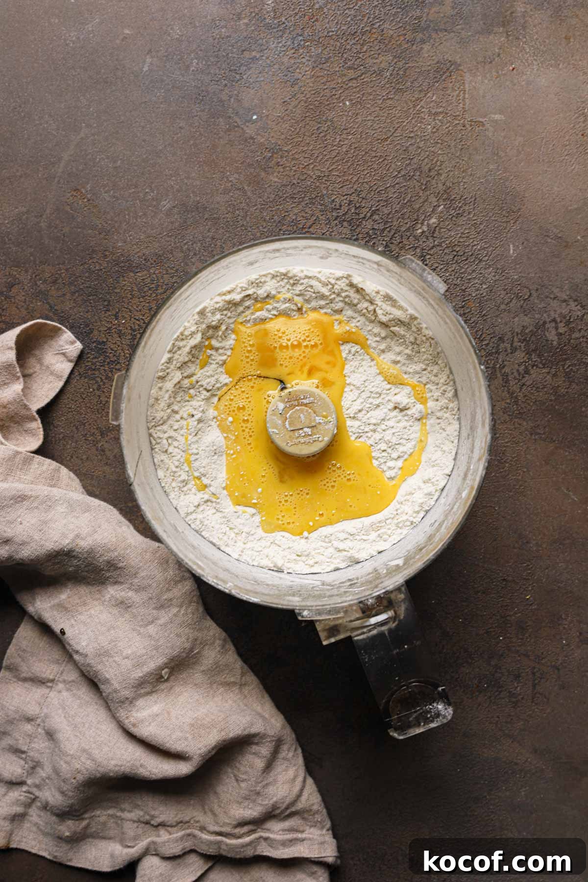 Italian Pasta Frolla Shortcrust Recipe for Tarts & Cookies 5 A bowl of a food processor with flour and beaten egg.